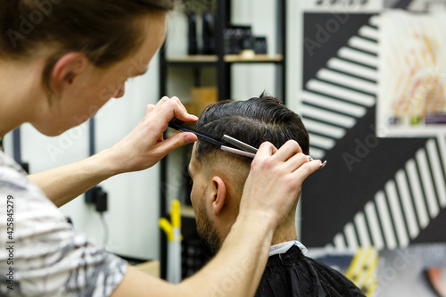 Barbershop. Master hairdresser makes hair and cuts beard