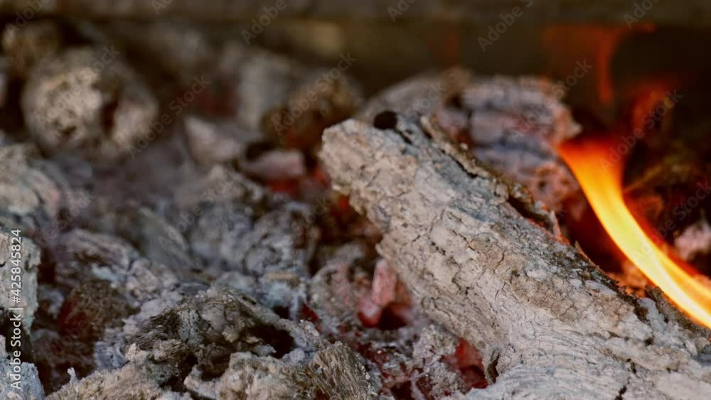 Close-up close-up in vertical slow motion mode of outdoor barbecue fire and meat grill with coals preparing food on a family picnic day. Close-up close-up in vertical slow motion mode of outdoor barbecue fire and meat grill with coals preparing food on a family picnic day.