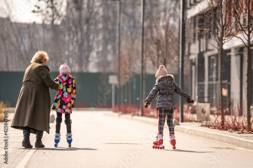 grandma teaches two granddaughters to roller skate