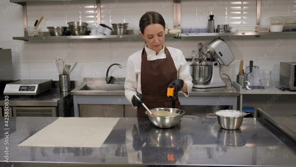 A pastry chef measures the temperature of the mousse with a laser thermometer. A pastry chef measures the temperature of the mousse with a laser thermometer.