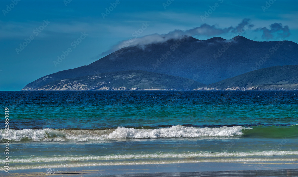 paissagem costeira com montanhas, mar, rochas, praias, casas e barcos