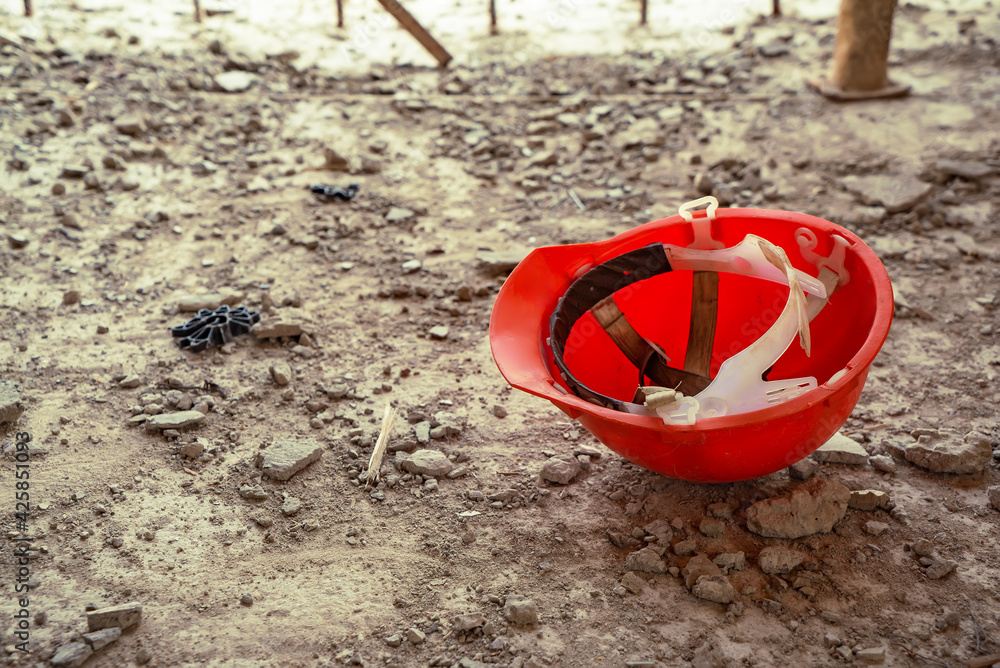 Red safety helmet lying on the concrete floor at the construction site Red safety helmet lying on the concrete floor at the construction site