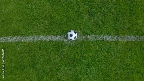 Drone footage of a professional football soccer player putting the ball at the center point of a stadium. 4k