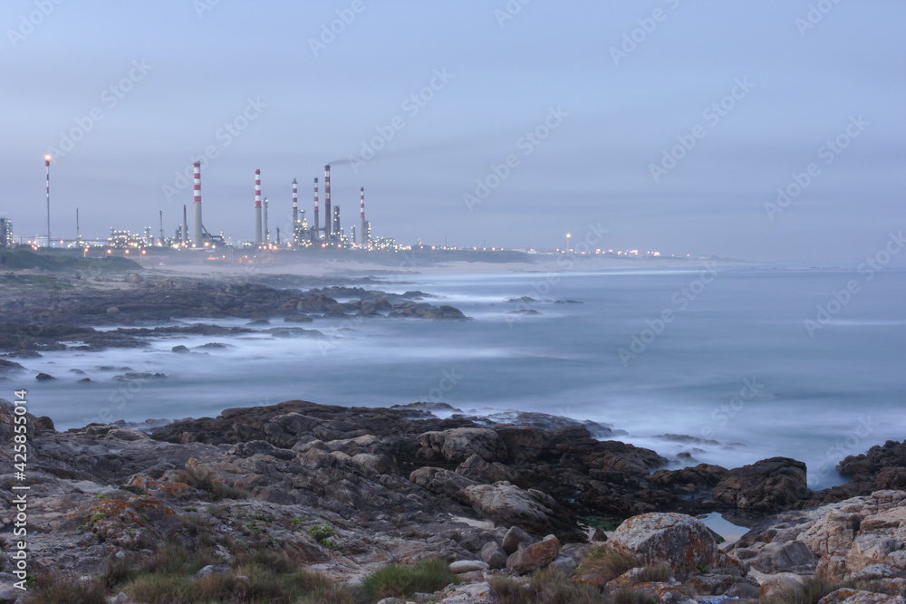 Oil refinery by the sea at dawn