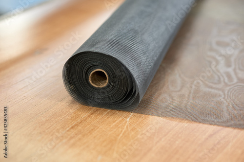 Round roll of mosquito net ready for making a window frame.