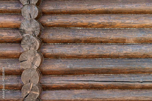 Rough wooden beams background, brown log wall texture close-up.