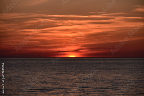sunset at sea with a calm water surface © gatis_photo