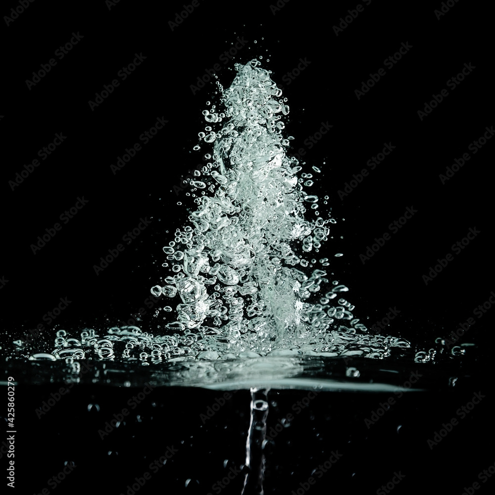 a jet of water on a black background. A splash and a bubble of air under the water. a jet of water on a black background. A splash and a bubble of air under the water.