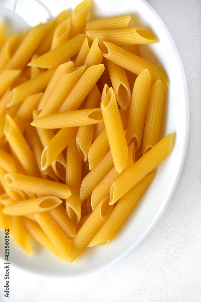 Yellow delicious pasta close-up on a white plate Yellow delicious pasta close-up on a white plate