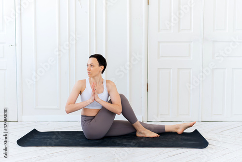 Young woman practicing yoga in a light background. Healthy lifestyle concept