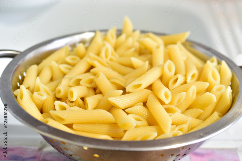 Freshly washed Italian pasta in a colander in the kitchen Freshly washed Italian pasta in a colander in the kitchen
