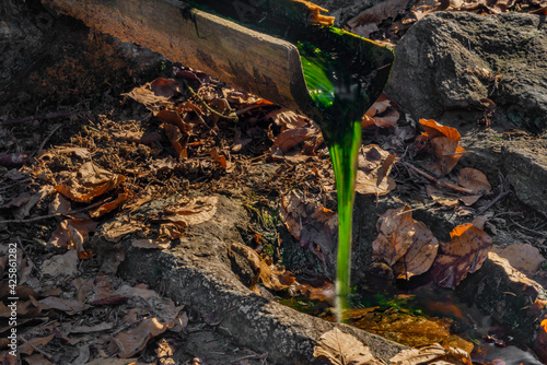 Small green spring with wooden pipe near Pancir hill in Sumava national park photo