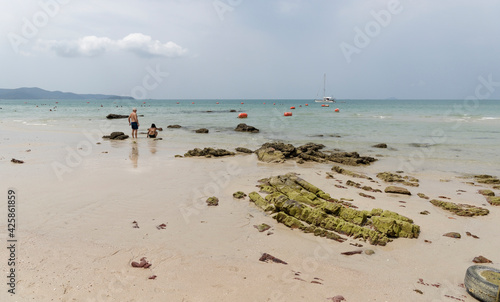 People sunbathe and swim.People walk on the beach after low tide © aleks