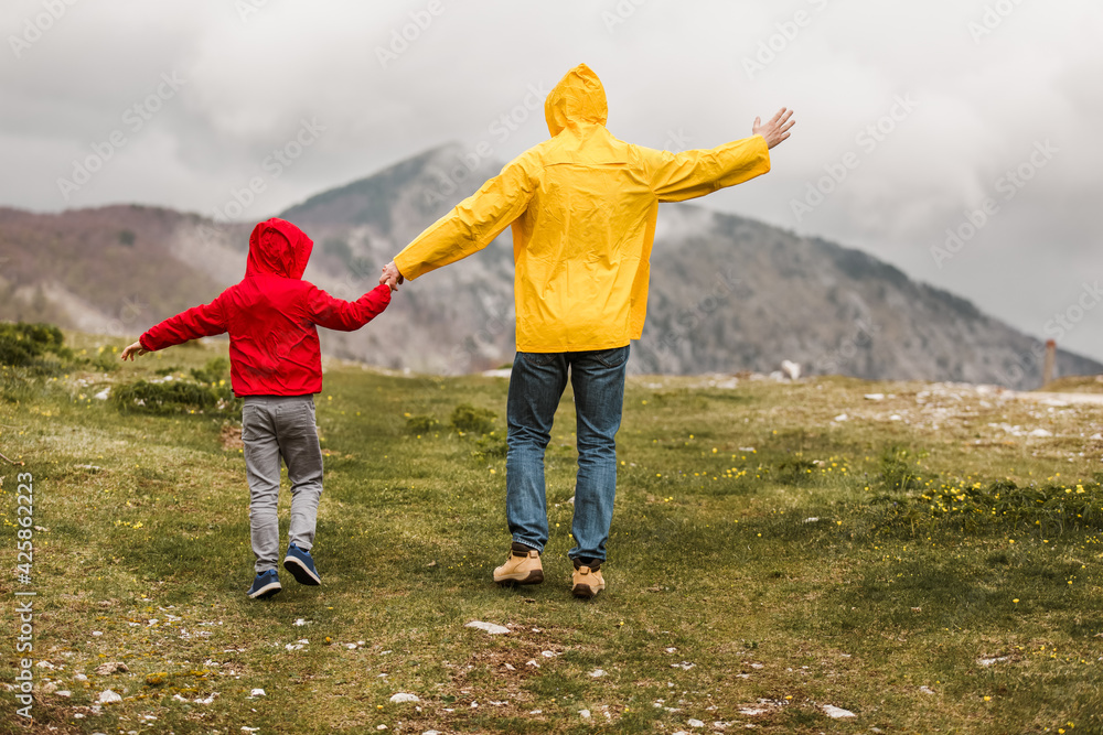 Father and son in the countryside on a rainy day