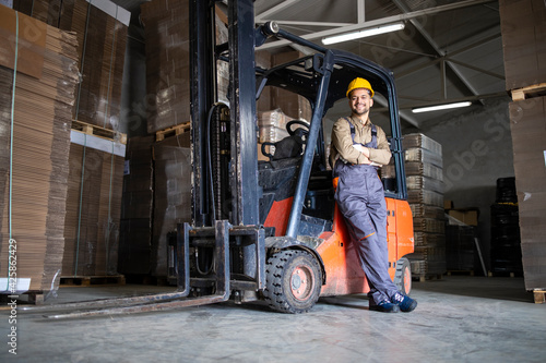 Experienced forklift driver in warehouse storage room. photo