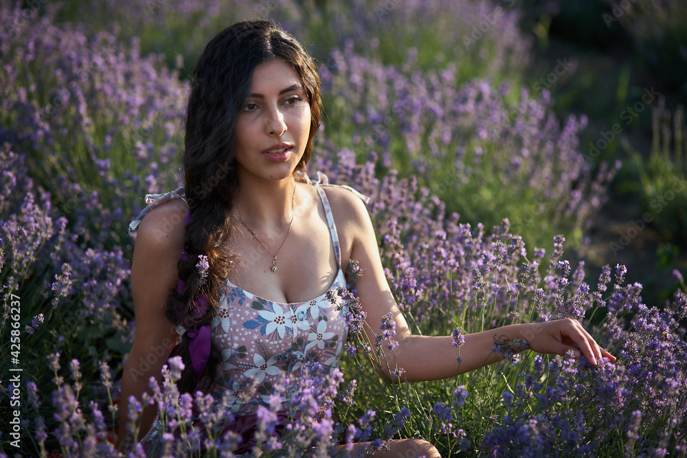 Portrait of lovely brunette girl in lavender field. Summer lavender model posing in front of the camera. Portrait of lovely brunette girl in lavender field. Summer lavender model posing in front of the camera.