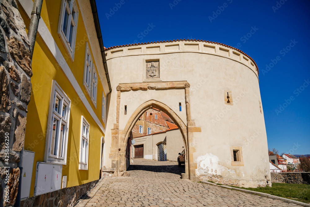 Zatecky Barbican, Medieval gothic fortification, fortress wall, sunny day, town gate, old stronghold, city coat of arms, renaissance yellow historical building, Kadan, Czech Republic