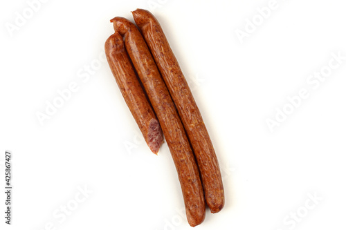 Three sausages lie on a white background.The sausage is sliced. Isolated