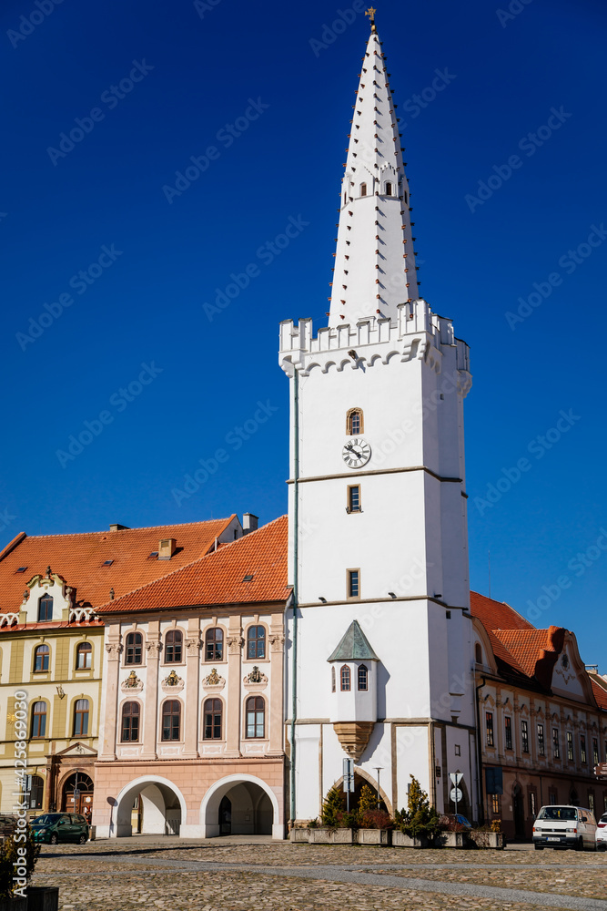 Main town Peace square, gothic white city hall tower, House at the golden sun, Medieval street, renaissance historical buildings, ancient arcade, sunny day, Kadan, Czech Republic