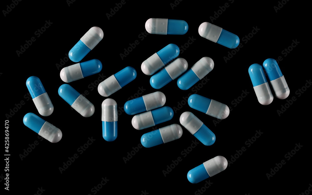 Blue white capsule, pills medicine isolated on black background 