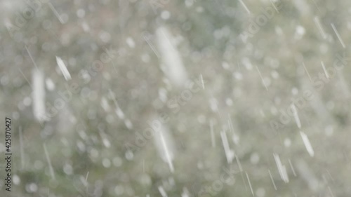 Blurred background of falling snow in spring time.