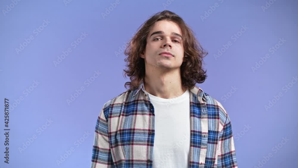 Inflexible man with long hairstyle disapproving with no head sign, nods head disapprovingly. Denying, Rejecting, Disagree, Portrait of guy on violet studio background. Inflexible man with long hairstyle disapproving with no head sign, nods head disapprovingly. Denying, Rejecting, Disagree, Portrait of guy on violet studio background.