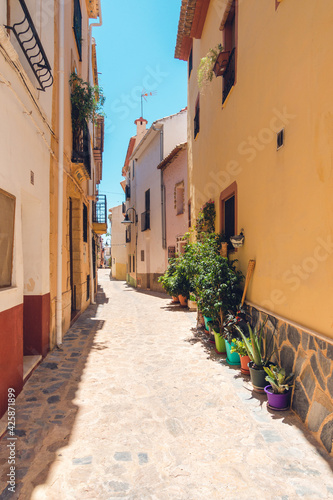 Finestrat  Alicante province  Spain. Beautiful quiet narrow street of small Finestrat village old town with old buildings  stone pavement at sunny day