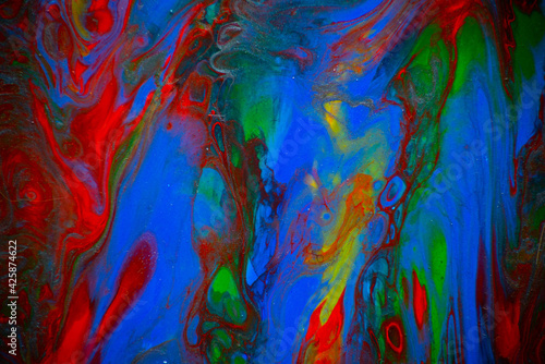 Texture in the style of fluid art. Abstract background with swirling paint effect. Liquid acrylic paint background. Red, green, yellow and blue colors.
