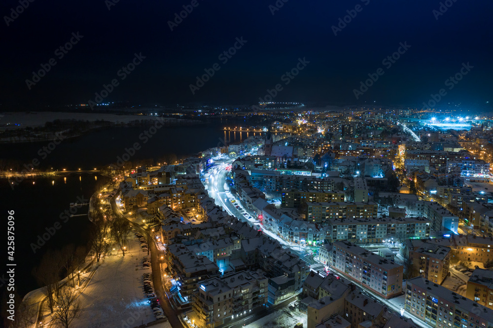 Elk city covered with snow. Night urban landscape. Aerial view.