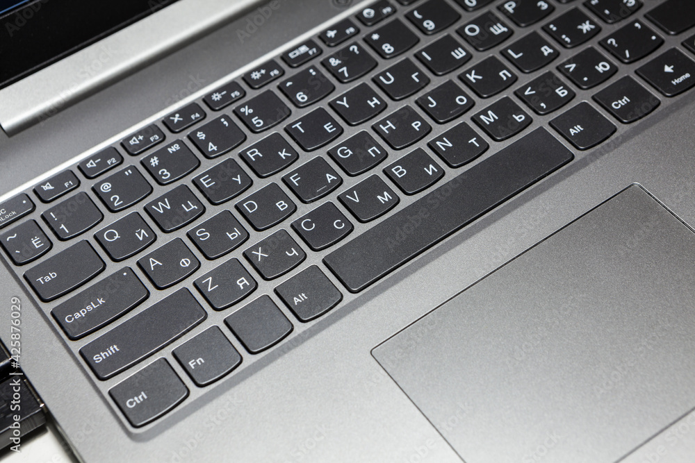 Silver laptop keyboard and touchpad, close-up view