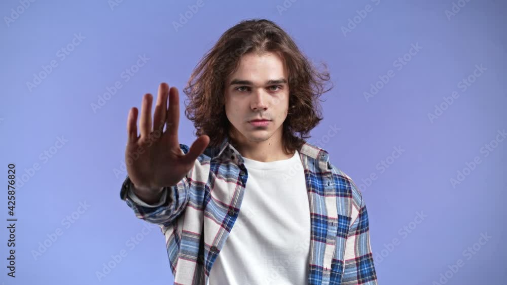 Portrait of serious man showing rejecting gesture by stop palm hand ...