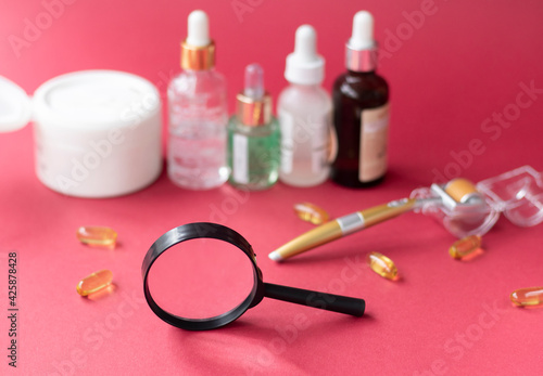 magnifying glass against the background of blurred face serums and dermoroller. The concept of finding the right skin care. High quality photo photo