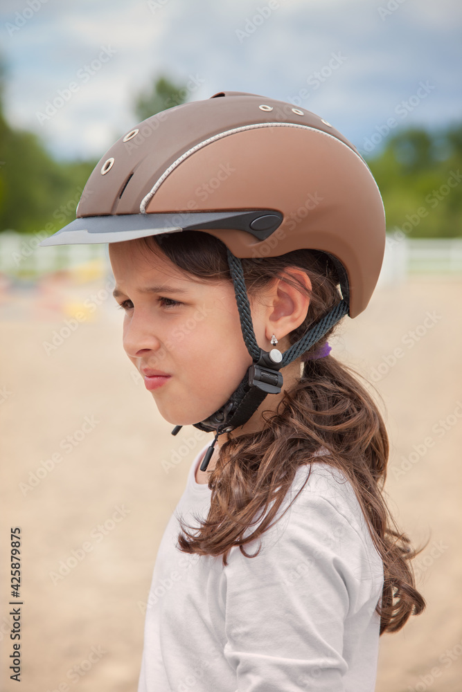 Foto de Young Girl Wearing a Horse Riding Helmet do Stock Adobe Stock