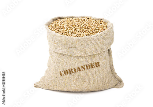 Seeds of coriander in a sack of isolated on a white background. Coriander in a burlap sack. Healthy food. Coriander in a jute bag. Vegan food