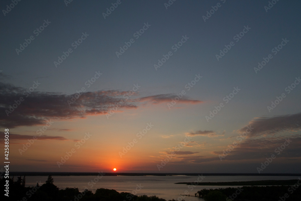 Seascape. View of the bay and ocean at sunset. The beautiful dusk colors and hiding sun in the horizon. Seascape. View of the bay and ocean at sunset. The beautiful dusk colors and hiding sun in the horizon.