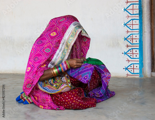 Schilderij op canvas Verhüllte Frau in bunten Stoffen in Gujarat - Indien