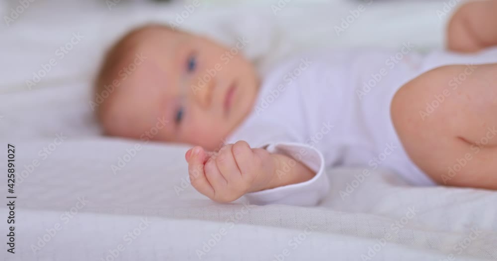 Close-up, little toddler's handle. Little fingers of a baby, a pretty baby is lying on a white blanket. Happy childhood. 4k, ProRes Close-up, little toddler's handle. Little fingers of a baby, a pretty baby is lying on a white blanket. Happy childhood. 4k, ProRes
