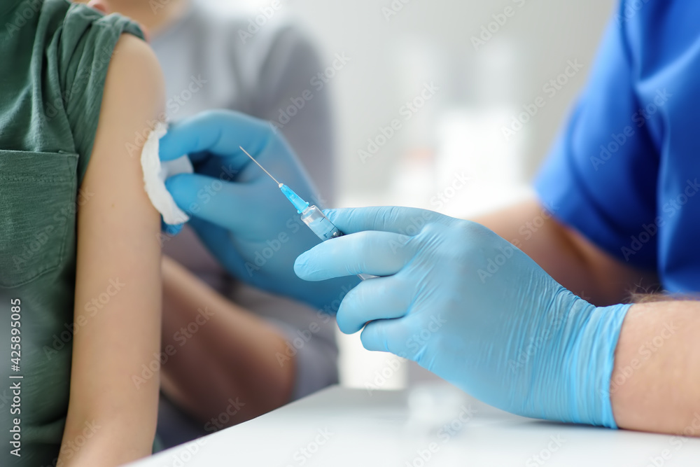 Doctor or nurse is preparing to give a injection vaccine against covid-19 to a little child. Vaccination of children. Herd immunity Doctor or nurse is preparing to give a injection vaccine against covid-19 to a little child. Vaccination of children. Herd immunity