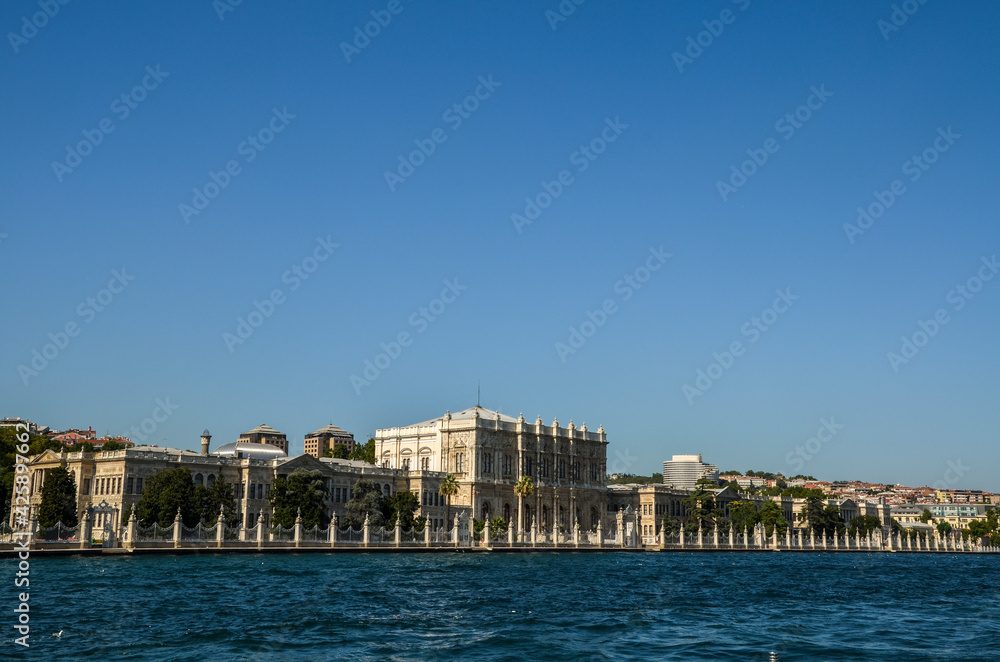 View of Dolmabahce Palace taken from the Bosporus, under a blue sky. Istanbul, Turkey View of Dolmabahce Palace taken from the Bosporus, under a blue sky. Istanbul, Turkey