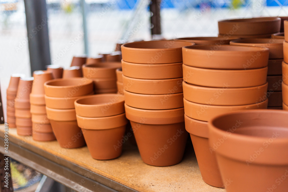 Stacked red clay pots for planting at sale in a garden center Stacked red clay pots for planting at sale in a garden center