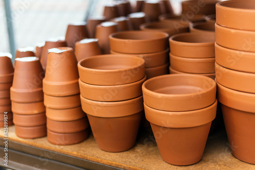 Stacked red clay pots for planting at sale in a garden center © Ana BG