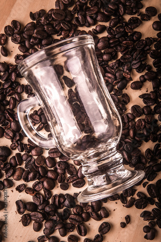 Empty cup of coffee with coffee beans around on a wooden board. Top view.