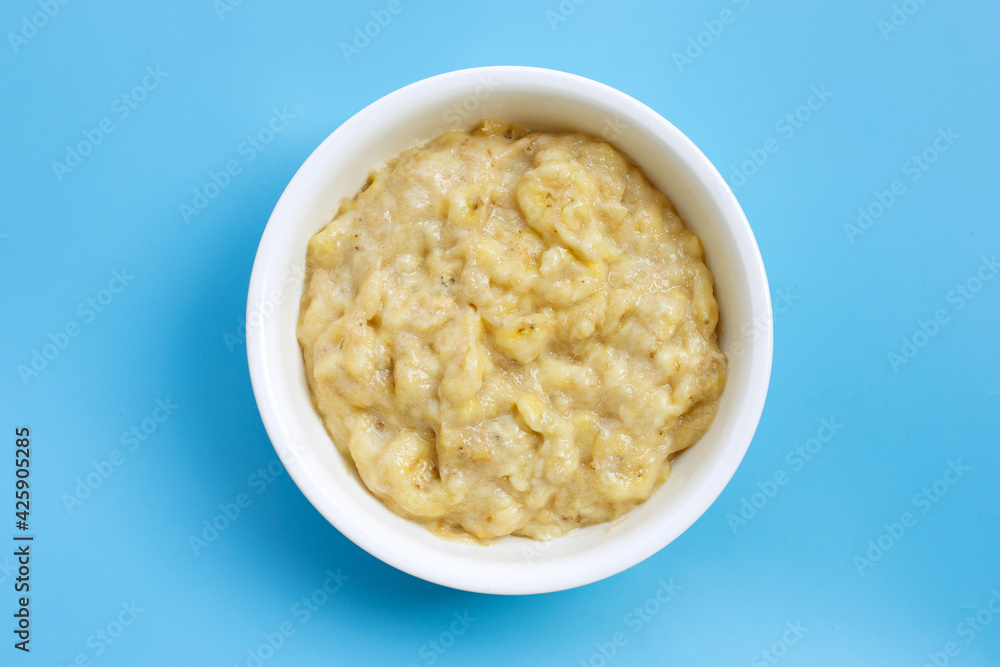 Mashed Bananas in bowl on blue background. Mashed Bananas in bowl on blue background.