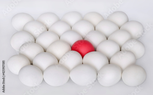 White boiled eggs and one red egg on white background