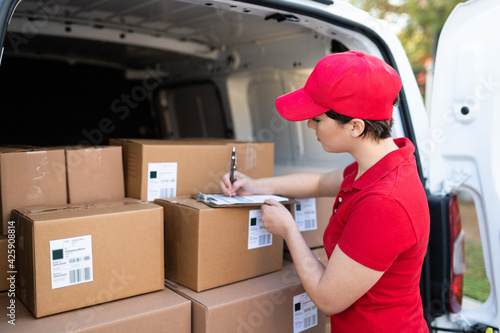 Female worker working to deliver packages on a delivery van