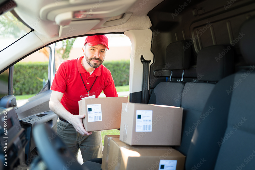 Portrait of a delivery man choosing a parcel from the van Portrait of a delivery man choosing a parcel from the van