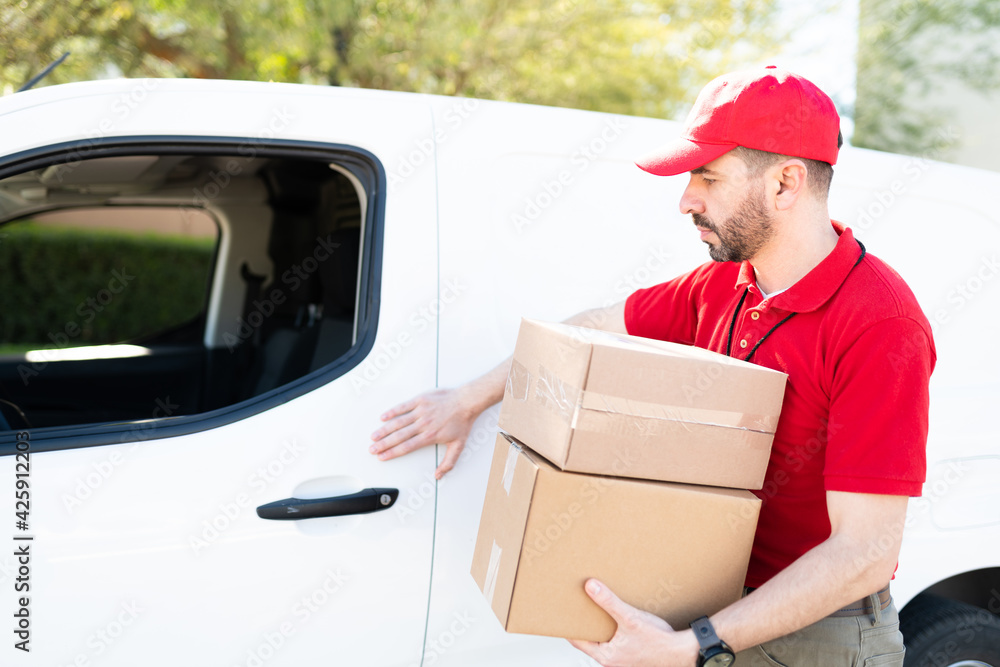 Delivery courier picking up packages to deliver in a truck Delivery courier picking up packages to deliver in a truck