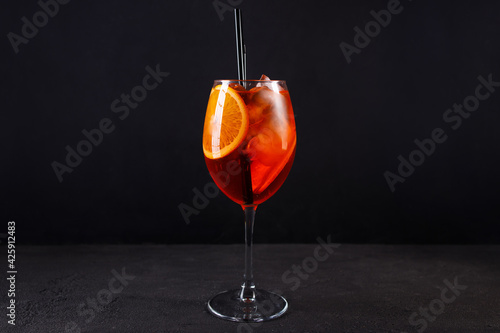 Glass of aperol spritz cocktail on black background