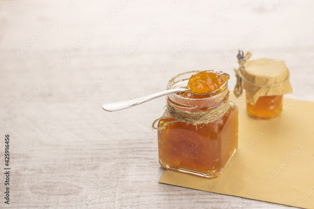 Selective focus to homemade fruit jam in spoon on glases jar. Copy space. Selective focus to homemade fruit jam in spoon on glases jar. Copy space.