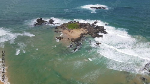 Drone Towards Rocky Headland With White Waves Splash Through Rocks At Sawtell Beach Near Bonville Peninsula In New South Wales, Australia. - Zoom In photo